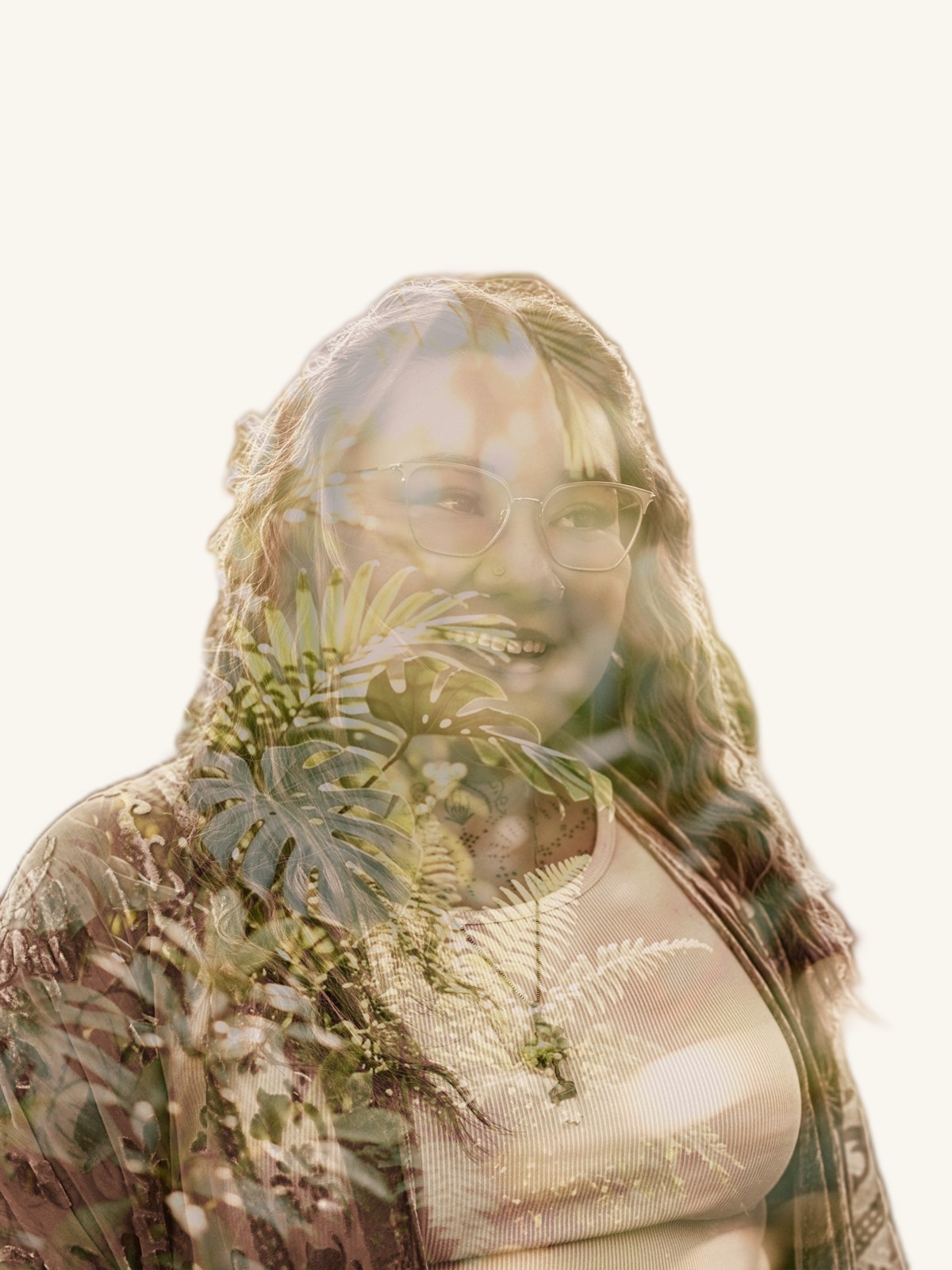 A double-exposure portrait of Xsana Saphire — monstera and fern leaves blooming through her smiling form